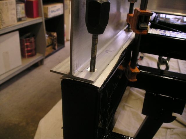 4"x3"x1/8" aluminum T, anchored to the frame to encase the floor structure