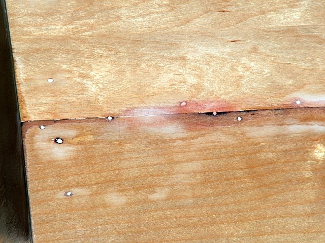Plywood joint and screw holes filled with epoxy filler.  It doesn't look too smooth, but by sanding, filler, and CPES seems to make a smooth feeling surface.