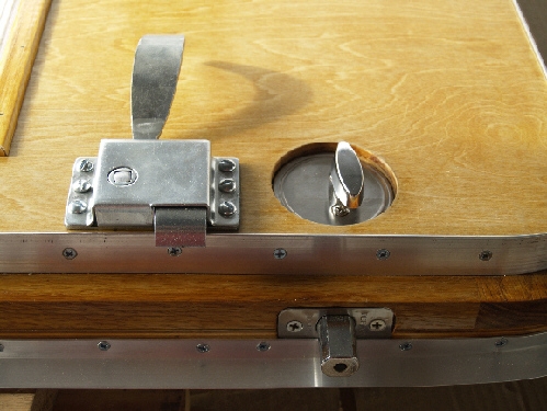 Detail of oak door showing trim, deadbolt and door handle.