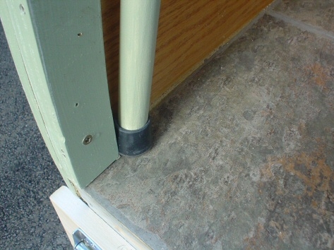 Rubber tip at bottom to prevent slipping.  Hopefully all three things...clasp, velcro and rubber tip on end of pole will prevent either pole from becoming displaced by accident.