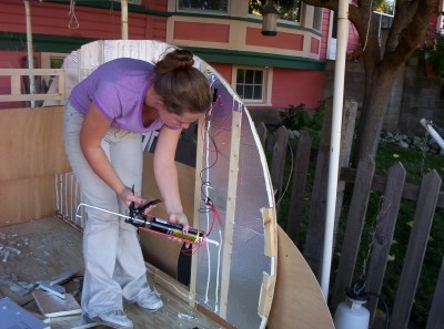 putting glue onto the insulation for the wall skin