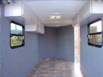 Walls carpeted, linoleum down and upper cabinets