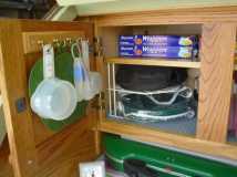 An old key holder doubles for pot holders and measuring utensils and frees up some drawer space.  Plus it closes nicely without hitting new shelf.