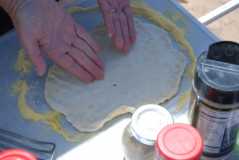 Sprinkle flex board with cornmeal and spread pizzadough